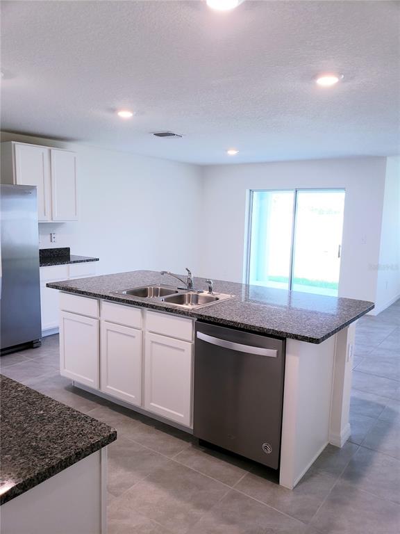 12211 Kingsley Trail Parrish, FL 34219 - Photo 13 of 28 a kitchen with granite countertop a sink and a stove