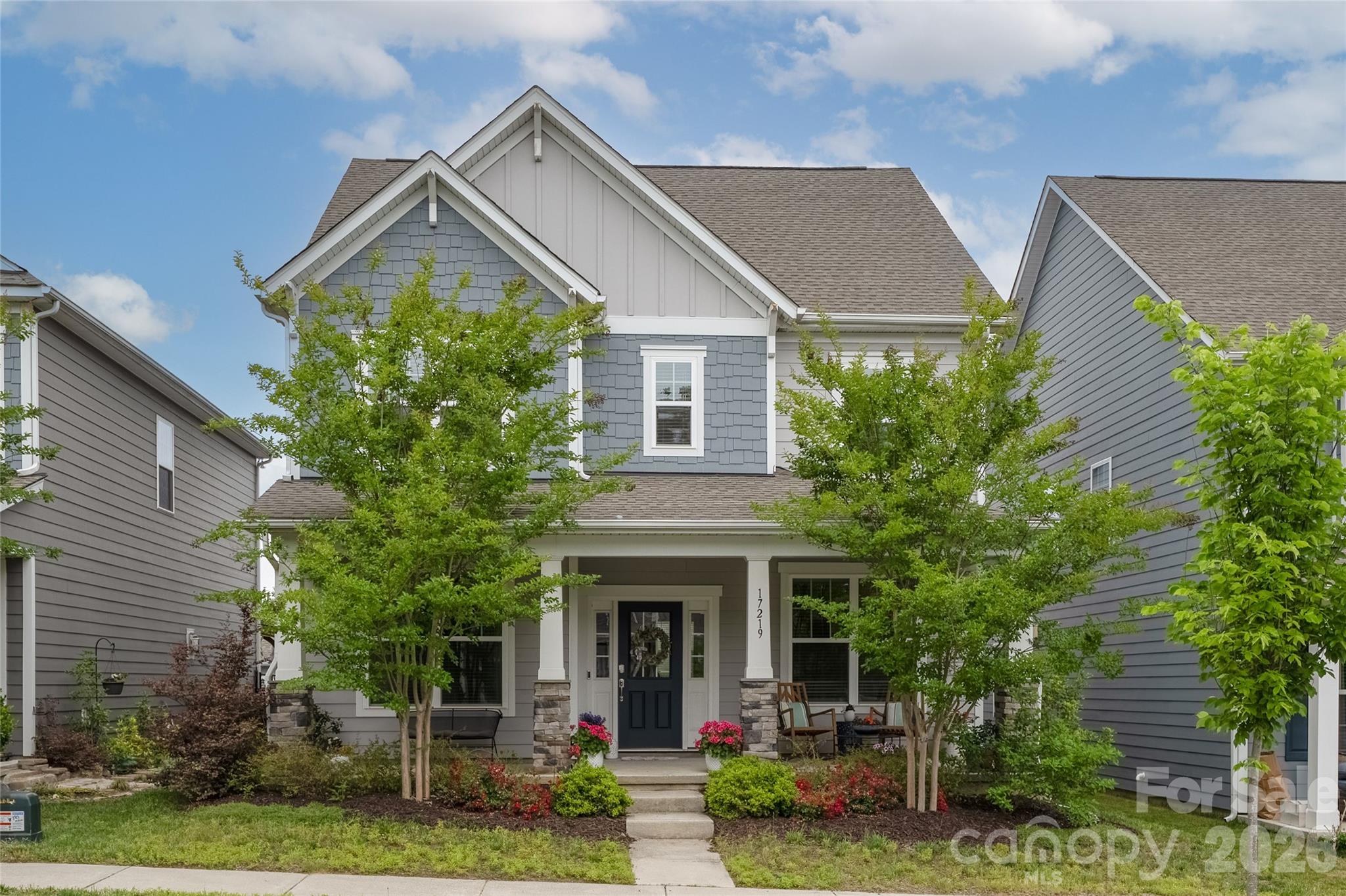 front view of house with a yard and potted plants