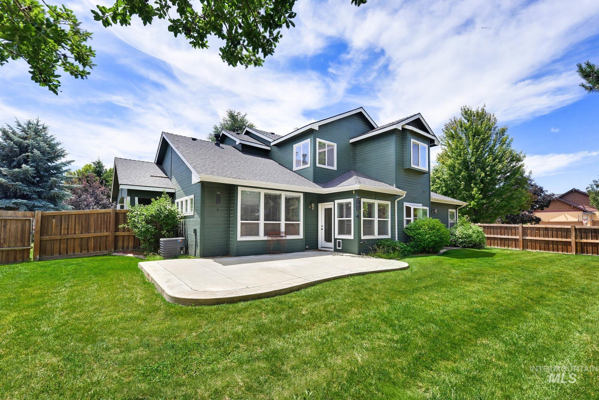 2172 West Cedar Grove Street Meridian, ID 83646 - Photo 38 of 49 Spacious backyard featuring a large concrete patio, established lawn, mature perimeter trees, and a privacy fence