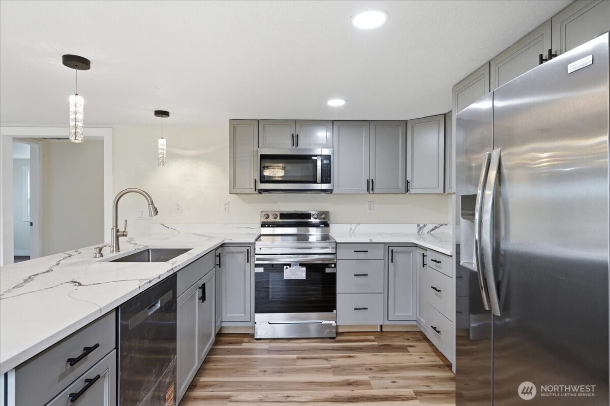 293 Barkley Road Manson, WA 98831 - Photo 10 of 40 a kitchen with stainless steel appliances granite countertop a sink a stove and a refrigerator