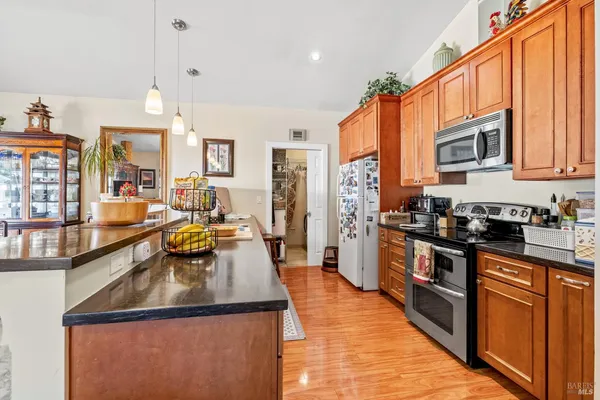 a kitchen with stainless steel appliances granite countertop a sink a stove and a refrigerator