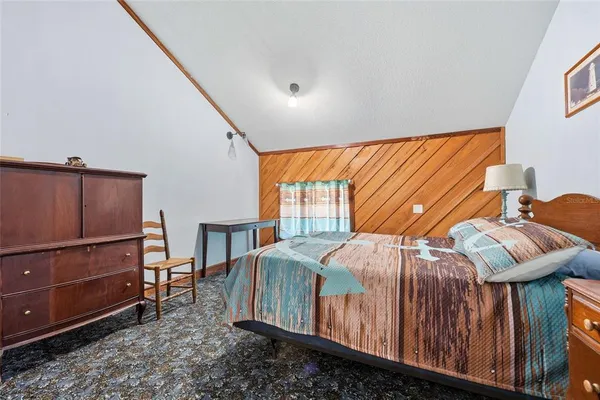 a bedroom with bed a lamp and a window