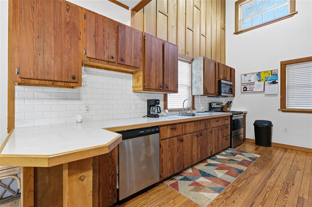 317 Cedar Street Steinhatchee, FL 32359 - Photo 10 of 32 a kitchen with stainless steel appliances granite countertop a sink a stove and a microwave