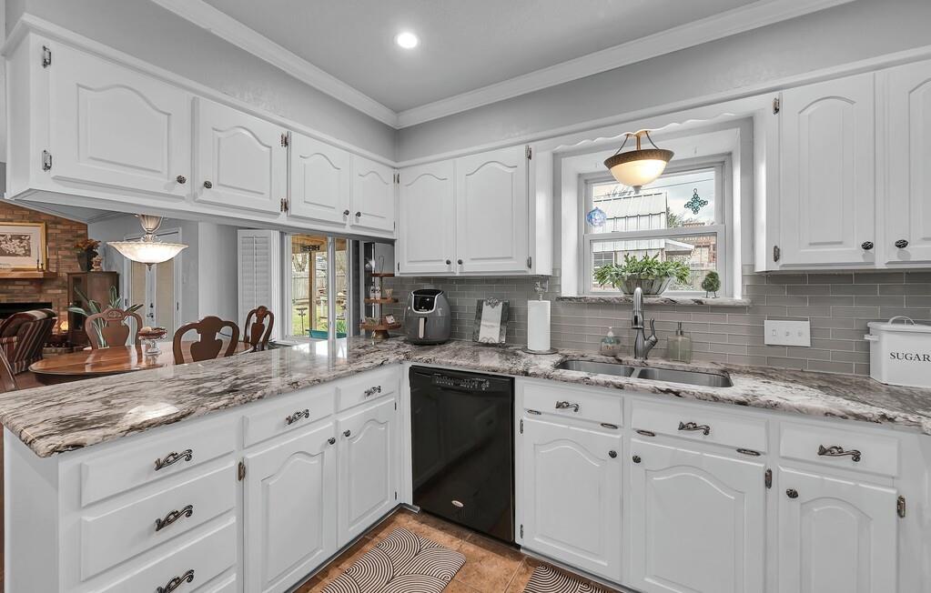 1065 Dendron Drive Hewitt, TX 76643 - Photo 12 of 32 a kitchen with granite countertop a sink white cabinets and window