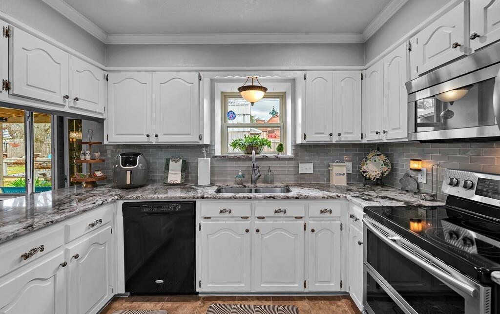 1065 Dendron Drive Hewitt, TX 76643 - Photo 10 of 32 a kitchen with stainless steel appliances granite countertop a sink a stove a microwave cabinets and a window