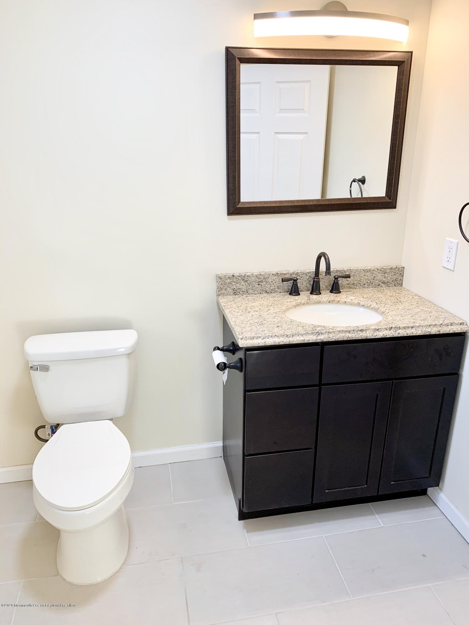61 Middlesex Road Matawan, NJ 07747 - Photo 3 of 14 a bathroom with a toilet a sink and mirror