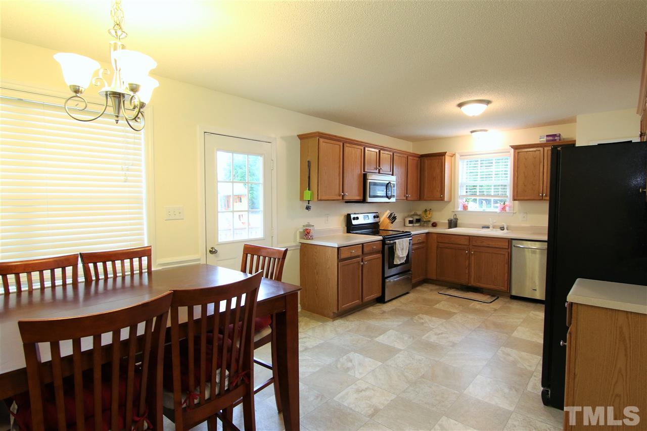 364 Rosa Circle Willow Spring, NC 27592 - Photo 8 of 21 a kitchen with a refrigerator a stove a sink a dining table and chairs