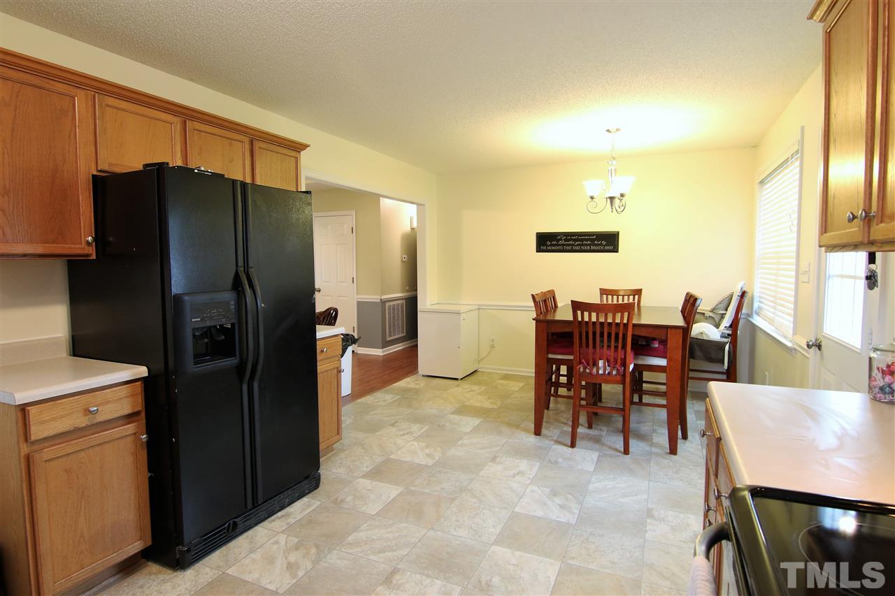 364 Rosa Circle Willow Spring, NC 27592 - Photo 9 of 21 a kitchen with stainless steel appliances kitchen island granite countertop dining table chair and a refrigerator