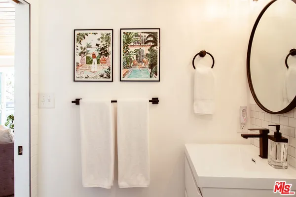 a bedroom with a bed a chandelier and potted plants