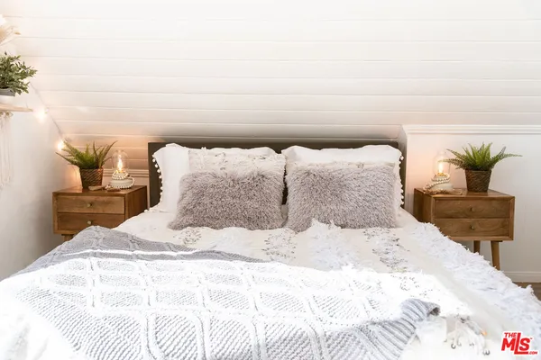 a bedroom with a bed and a potted plant