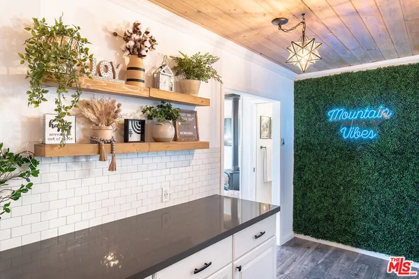 a vase with flowers sitting on a floor in front of a door