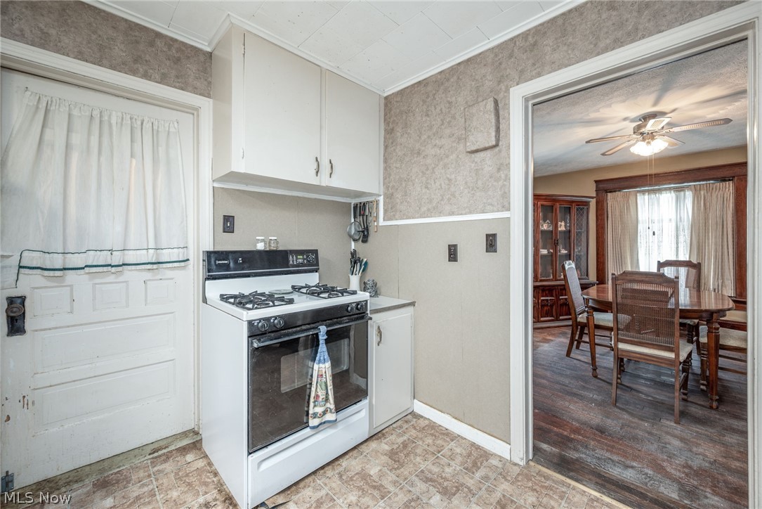 267 West Riddle Avenue Ravenna, OH 44266 - Photo 8 of 47 Galley kitchen featuring white cabinetry with ample storage, gas range with stainless steel appliances, tile flooring, and an open pass-through to the dining area