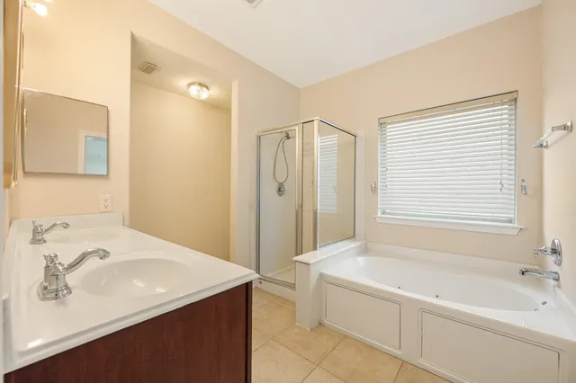 a bathroom with a tub a sink and a shower