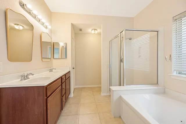 a bathroom with a tub sink and mirror