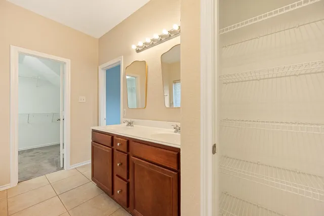 a bathroom with a double vanity sink a mirror and a shower