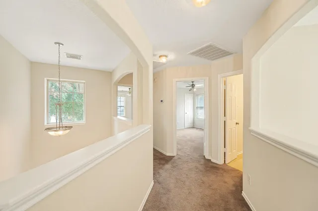 a view of hallway with windows and chandelier