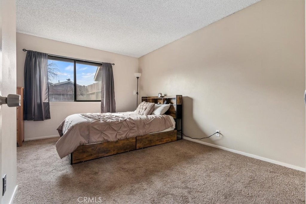 2 Village Lane Tehachapi, CA 93561 - Photo 18 of 32 a bed sitting in a spacious bedroom next to a window