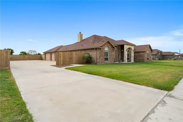 a view of a house with a big yard and large trees