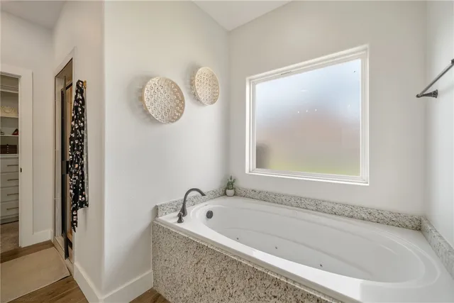 a bathroom with a tub a window and a shower