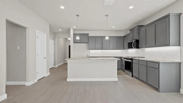 a kitchen with granite countertop cabinets and chandelier