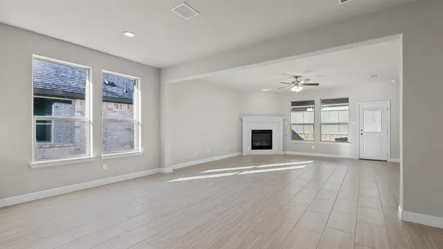 a large white kitchen with kitchen island a sink a stove a refrigerator and white cabinets
