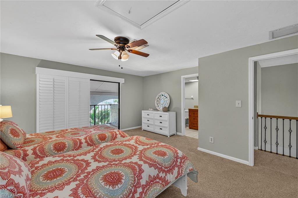1400 Blue Point Avenue, Unit 202 Naples, FL 34102 - Photo 11 of 18 a bedroom with a large bed and a chandelier