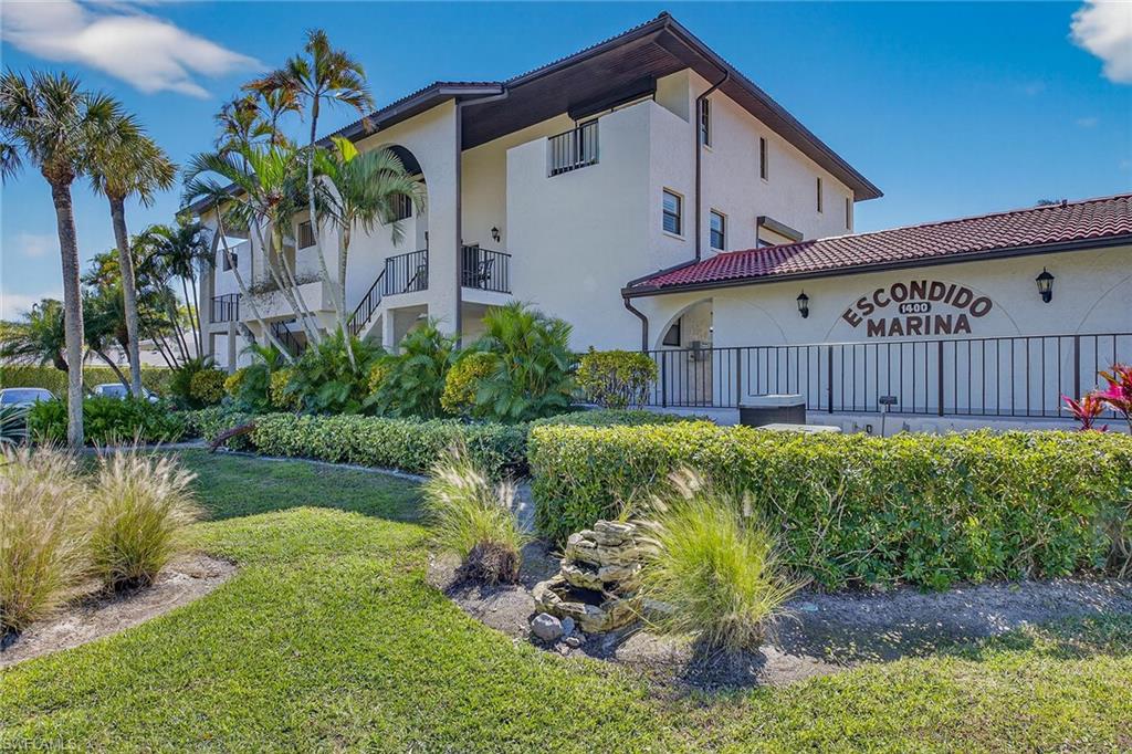 1400 Blue Point Avenue, Unit 202 Naples, FL 34102 - Photo 2 of 18 a front view of a house with garden