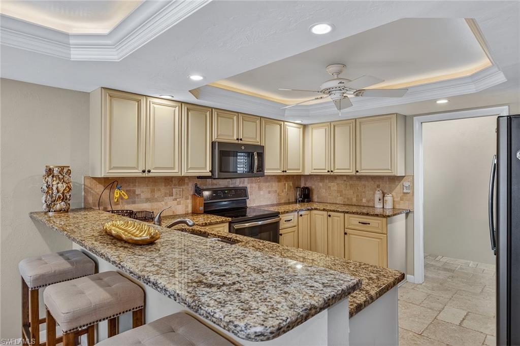 1400 Blue Point Avenue, Unit 202 Naples, FL 34102 - Photo 6 of 18 a kitchen with granite countertop a sink counter top space appliances and cabinets