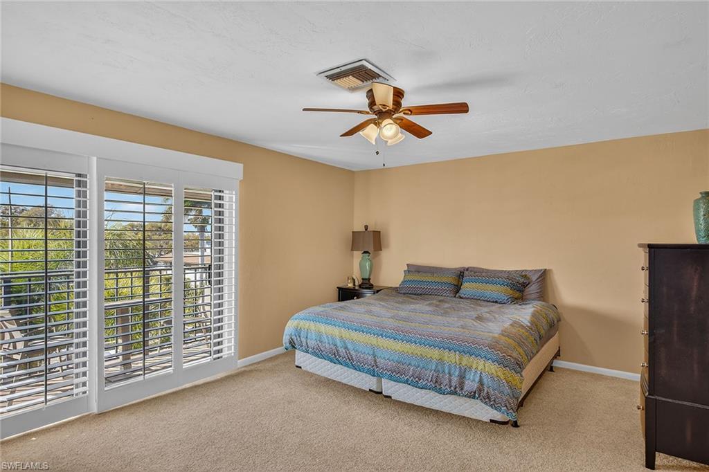 1400 Blue Point Avenue, Unit 202 Naples, FL 34102 - Photo 8 of 18 a bedroom with a bed and a chandelier