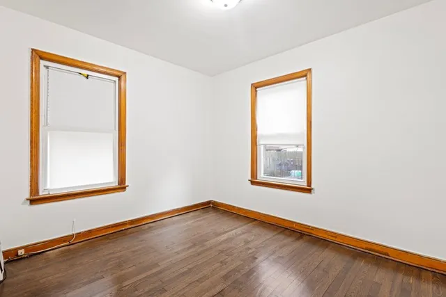 an empty room with wooden floor and a window
