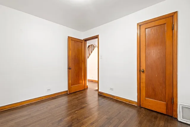 an empty room with wooden floor and closet