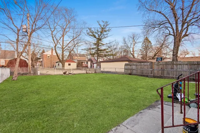 a view of an house with backyard space and a tree