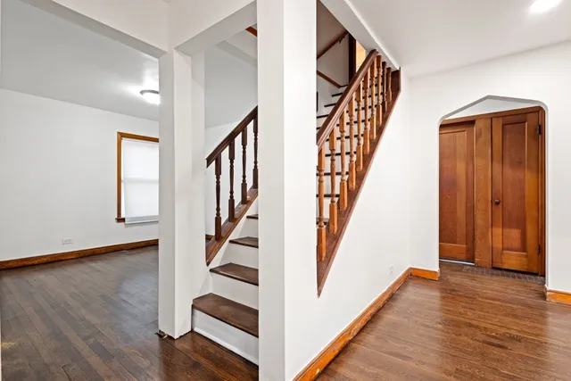 a view of front door with wooden floor and stairs