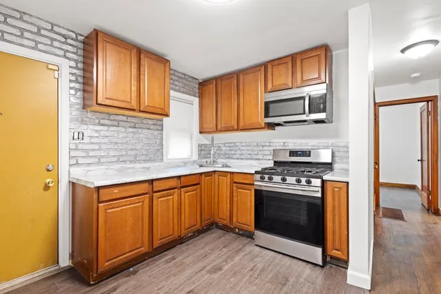 a kitchen with stainless steel appliances granite countertop a stove a sink and a microwave