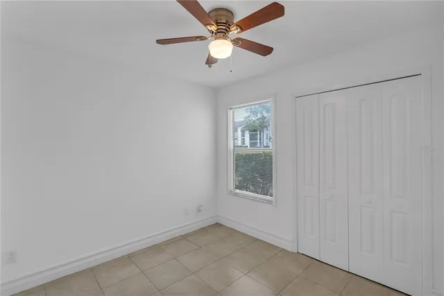 an empty room with a window and a fan