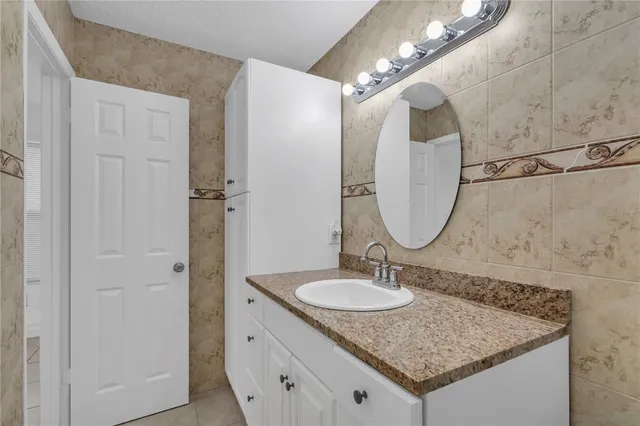 a bathroom with a sink vanity granite and a mirror