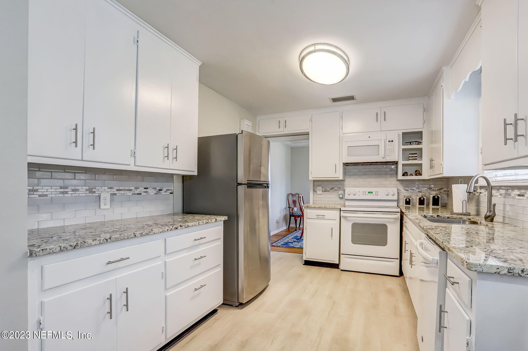 4375 Timuquana Road Jacksonville, FL 32210 - Photo 14 of 24 a kitchen with white cabinets and stainless steel appliances