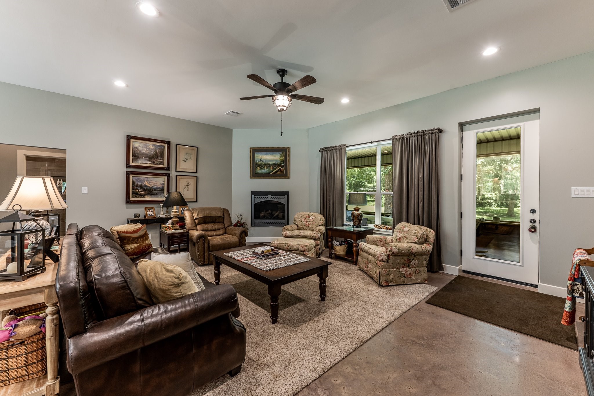 13334 Fultz Road Conroe, TX 77304 - Photo 8 of 49 Cozy up in style—this inviting living room features rich textures and a sleek gas fireplace for year-round ambiance.