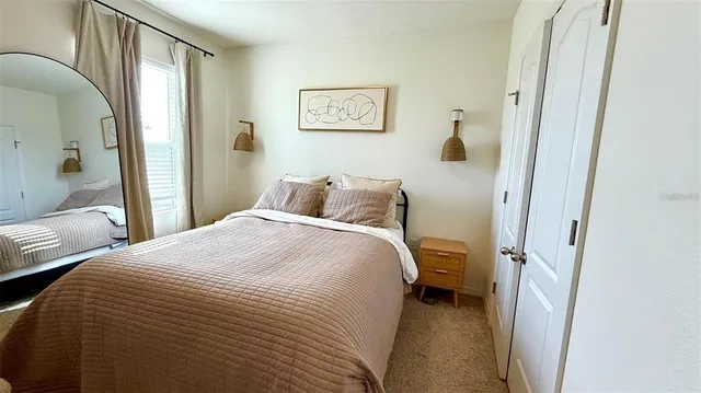 a bedroom with a bed and a painting on the wall