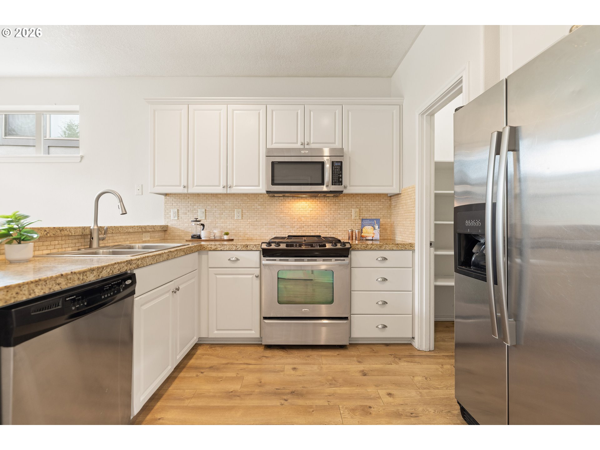 6512 Northwest 165th Avenue Portland, OR 97229 - Photo 11 of 42 a kitchen with stainless steel appliances granite countertop a refrigerator sink and stove