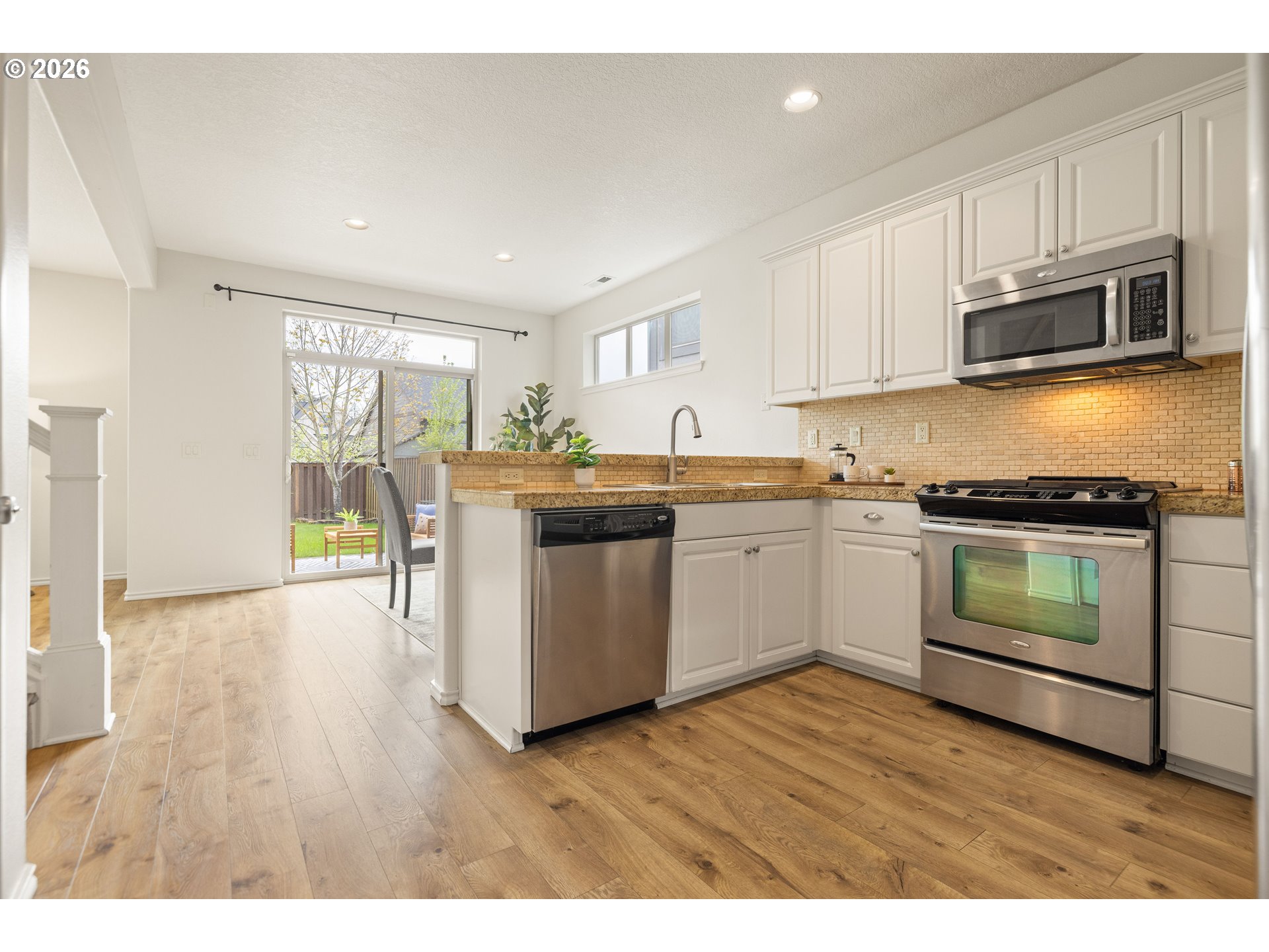 6512 Northwest 165th Avenue Portland, OR 97229 - Photo 8 of 42 a kitchen with stainless steel appliances a white stove top oven cabinets and a microwave