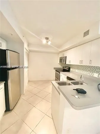 a kitchen with a sink a stove top oven a counter space and a window