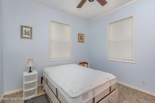 a white bed sitting in a bedroom next to a window