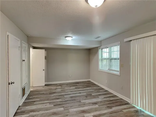 a view of an empty room with closet and a window