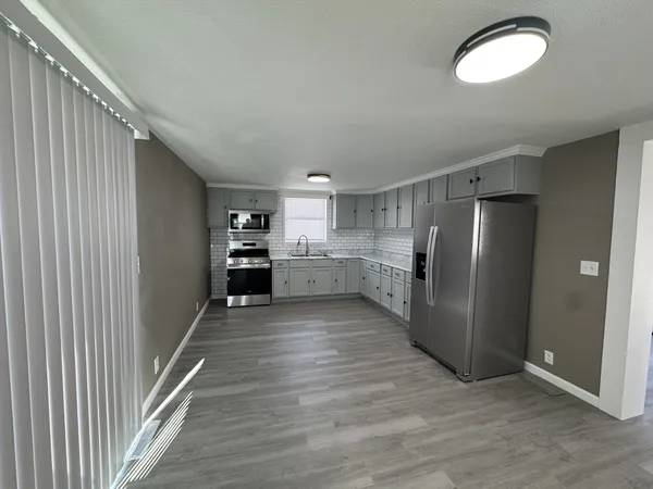 a kitchen with stainless steel appliances granite countertop a refrigerator and a sink