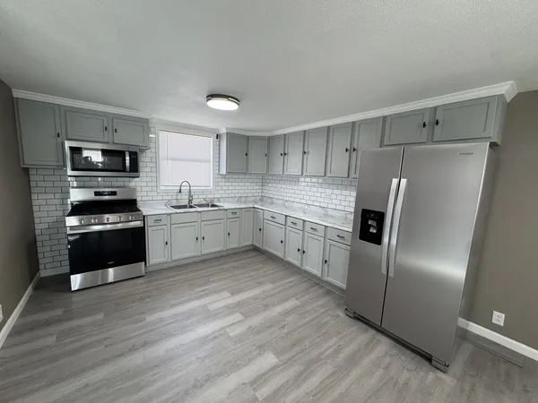 a kitchen with stainless steel appliances a refrigerator sink and cabinets