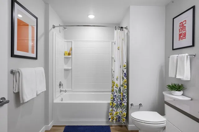 a bathroom with a granite countertop sink toilet and shower