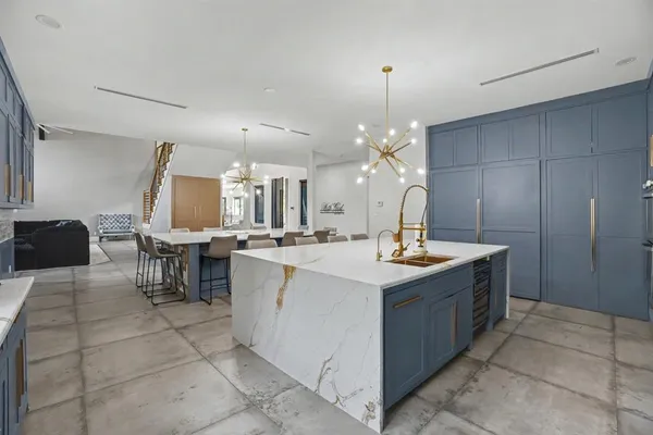 a kitchen with kitchen island granite countertop a sink counter top space and cabinets