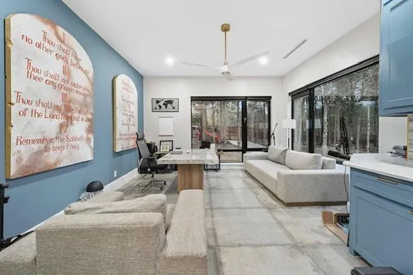a living room with furniture and large windows