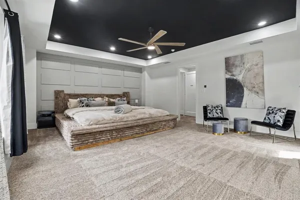 a spacious bedroom with a bed and a chair